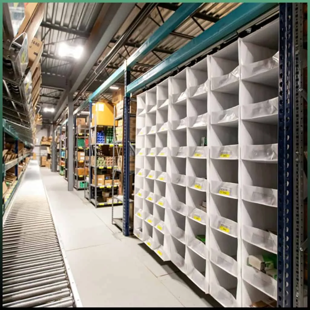 An e-commerce fulfillment floor — shelved inventory and pick stations, the dock-door end of an order placed online.