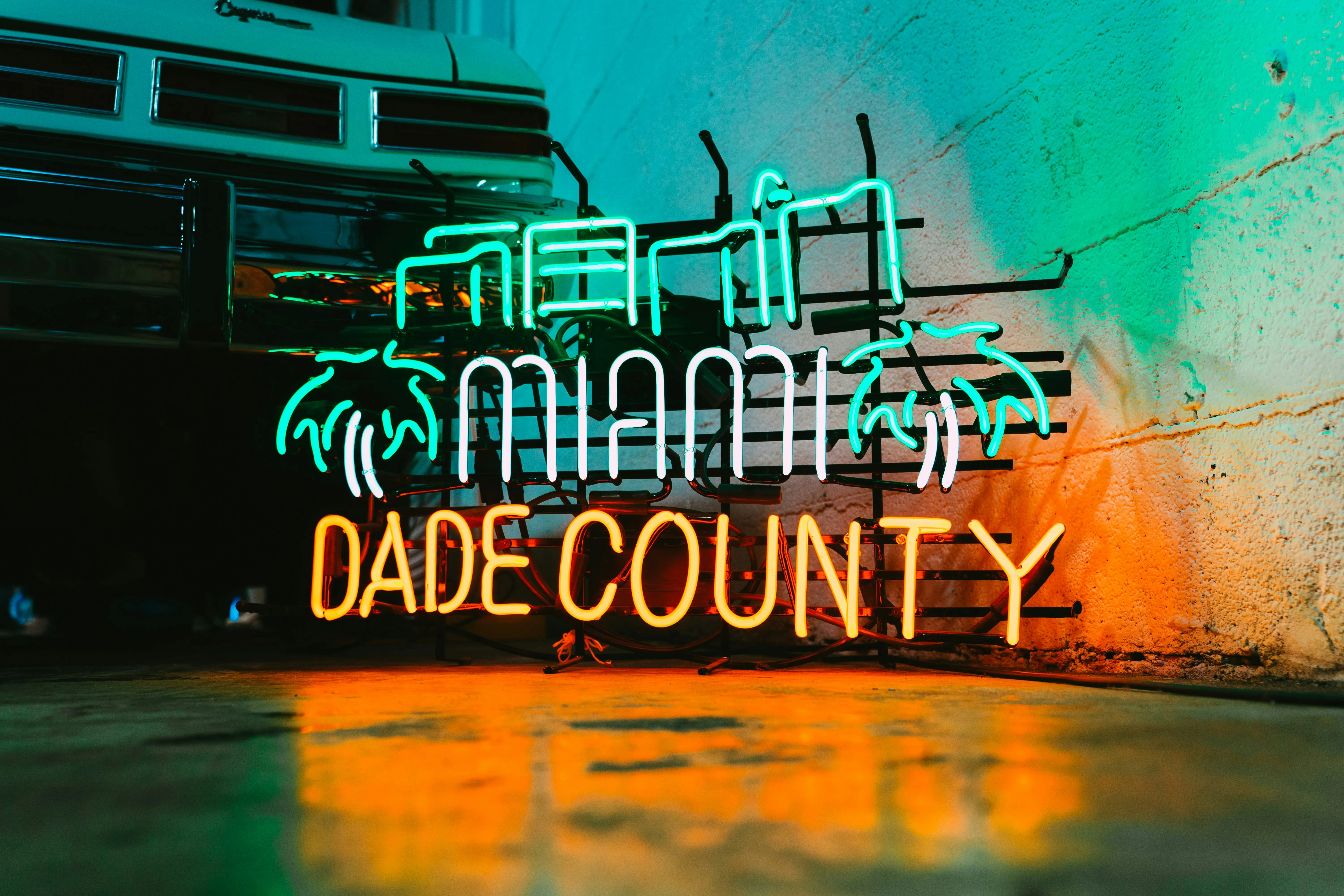 South Florida at neon evening — the Miami-Dade corridor at the edge of the working logistics ground that connects PortMiami, Port Everglades, and MIA to the Pompano Beach anchor.
