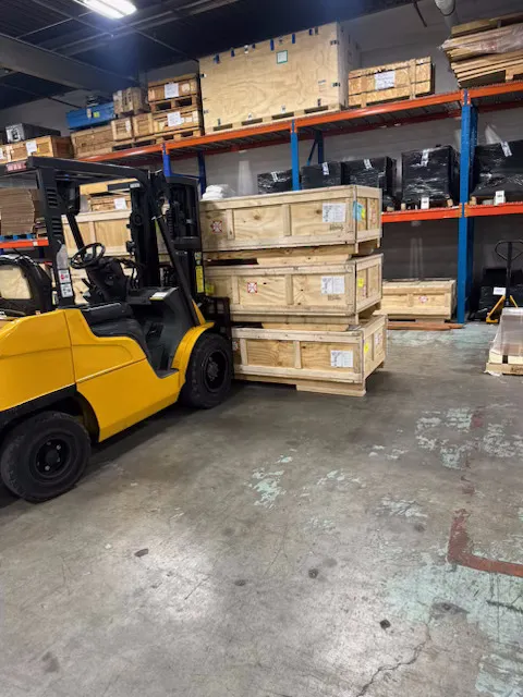 Interior of a Pompano Beach warehouse facility — pallet racking, clearly marked aisles, daylight conditions, the working floor of the South Florida cargo corridor.
